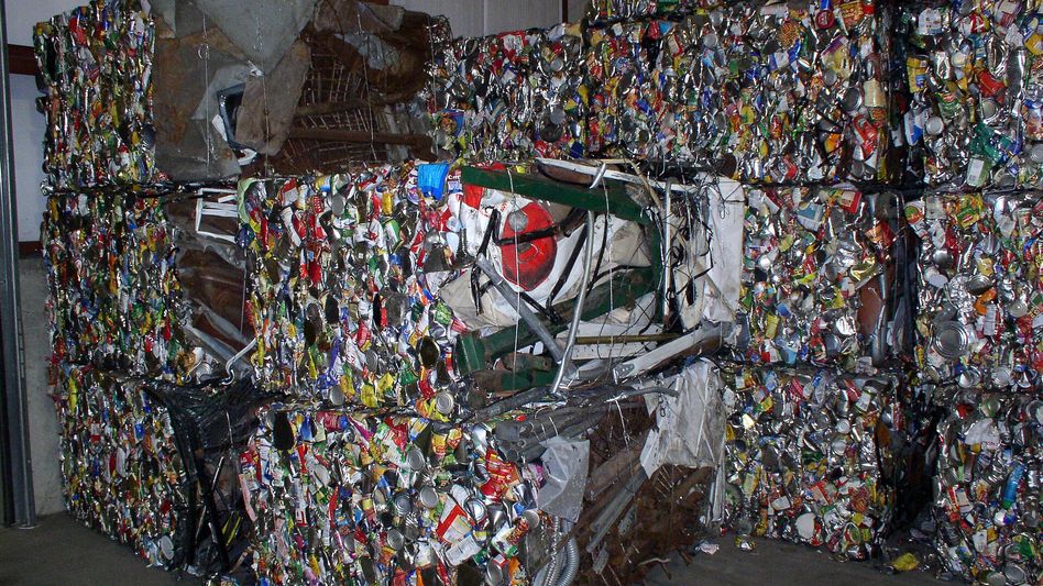 Electric material handler with cable reel sorting scrap in a covered bay